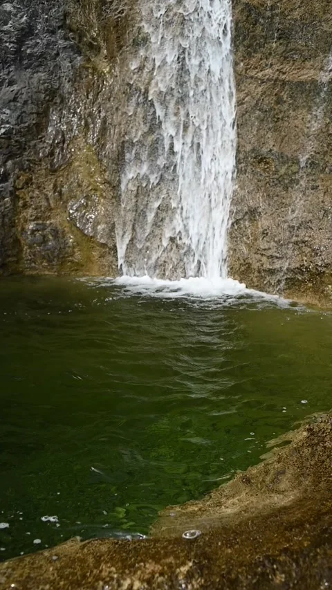 Vertical shot of the deep pond of a waterfall with green water, slow motion Stock-Footage 260888205