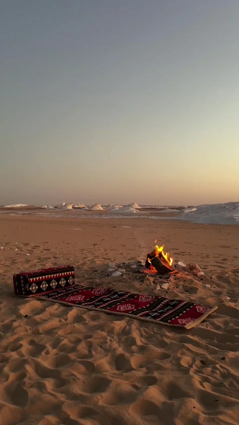 Vertical shot of desert camping scene with red arabian carpet on the sand and Stock Footage 340867644