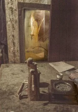 A vertical shot of a dirty table with a man's wooden sculpture, an ashtray, a 写真素材