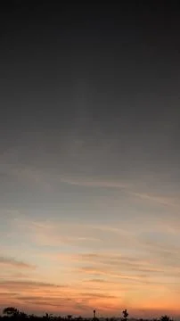 Vertical shot of a dramatic sunrise sky gradient from deep gray to warm ora.. Stock Photos