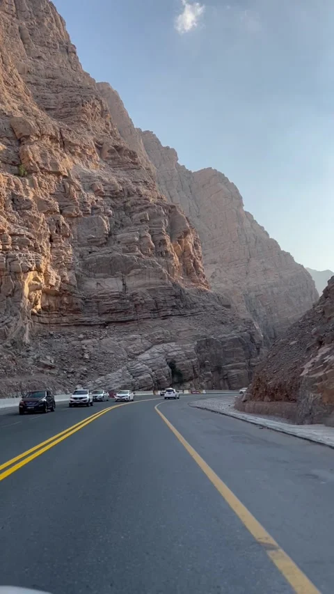 Vertical shot from driving car of sharp red mountains in UAE Golden Hour Video stock 227137173
