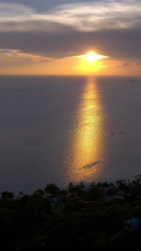 Vertical shot drone flight over the sea at sunset, with blue clouds and water on Stock Footage 275166725