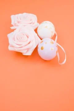 Vertical shot of easter eggs and roses on orange background Foto stock