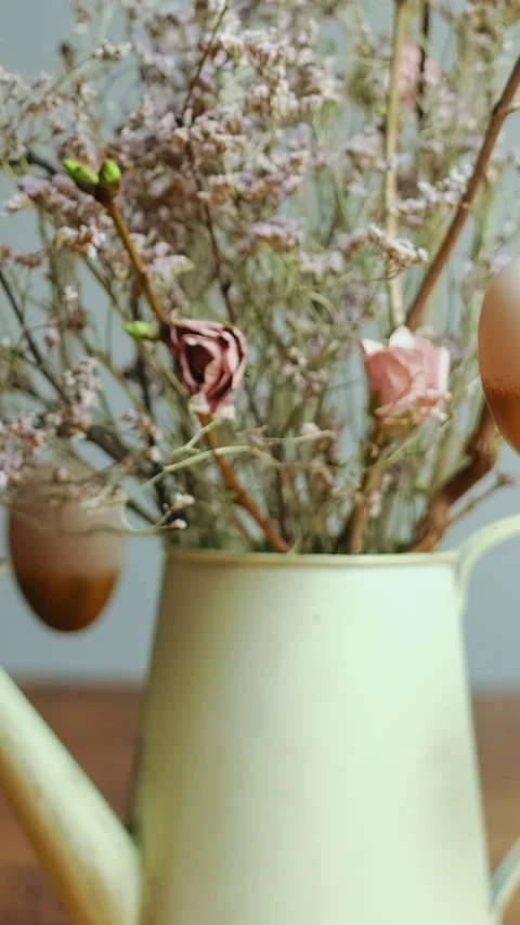 Vertical shot. Easter eggs hanging on branches. Easter flower arrangement. Stock Footage 253681384