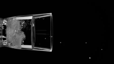 Vertical shot of effervescent tablet fall down into glass with water on black bg Stock Footage 204787032