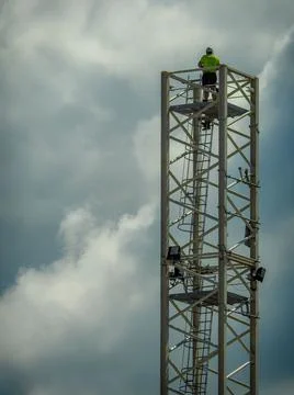 Vertical shot of engineers assembling a construction crane on a building site ag Fotos de archivo