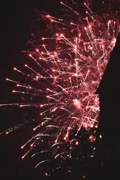 Vertical shot of exploding bright red fireworks in a night sky Stock Photos