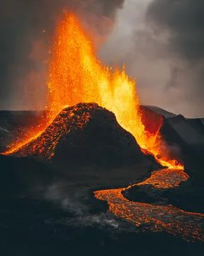Vertical shot of exploding burning lava near a volcano Foto stock