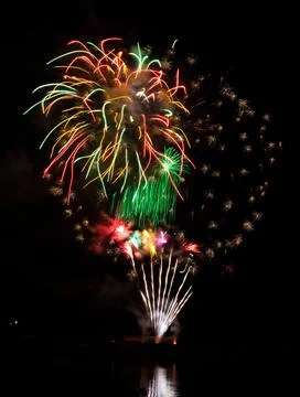 Vertical shot of exploding colorful fireworks in a dark night sky Stock Photos