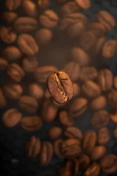 Vertical Shot of Falling Coffee Bean with Steam Stock Photos