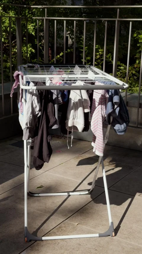 Vertical shot of family laundry drying on a sunny Berlin terrace in summer Stock Footage 346663262