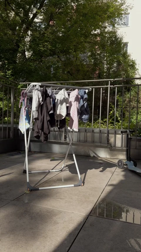 Vertical shot of family laundry drying naturally on a sunny Berlin terrace Stock Footage 346663268