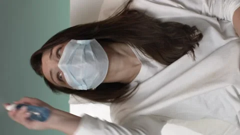 Vertical shot Female in mask sprayed antibacterial antiseptic around herself 動画素材 151987205