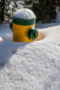 Vertical shot of fire hydrant partly covered with snow after a snow storm Stock Photos