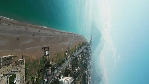 Vertical shot of a flying camera over a city beach on the Mediterranean Sea Stock Footage 227941799