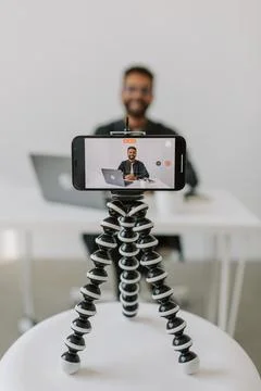 Vertical shot focused on phone camera young african man in glasses video call 4k Stock Photos