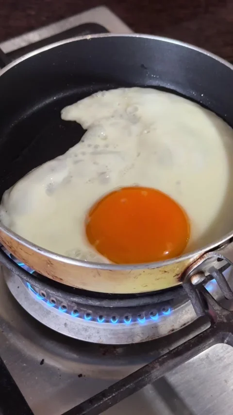 Vertical shot of Frying a Sunny Side Up Egg in a Small Pan Video stock 331873510