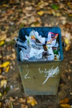 Vertical shot of a full garbage bin with a blurred background Stock Photos
