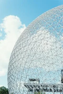 Vertical shot of a globe-shaped construction under the bright cloudy sky Stock Photos
