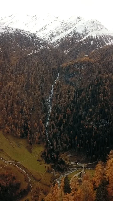 Vertical shot going down from a mountain revealing a forestry road Stock Footage 127467401