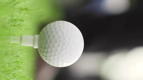 Vertical shot of golf ball on tee over blurred green background Stock Footage 131221278