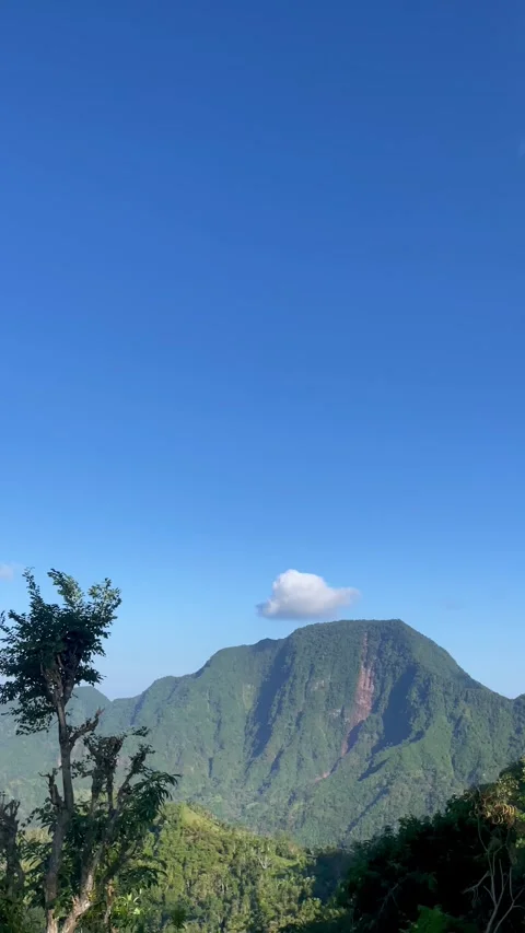 Vertical Shot of Green Mountain Peak with Cloud Under Blue Sky Vidéo 341552139