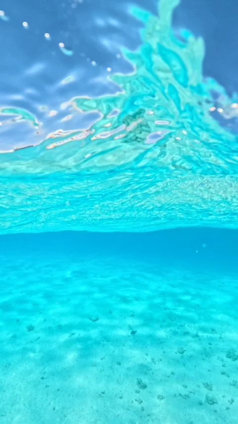 Vertical shot of half underwater view of white luxury yachts anchored in crystal 스톡 동영상 327573410