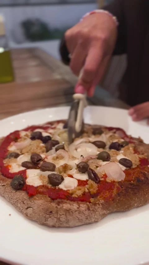 Vertical shot hands cutting homemade pizza with wheel cutter, Italy Stock Footage 339766738