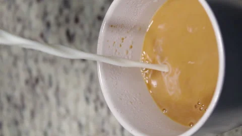 Vertical shot of hands serving hot black coffee with milk Stock Footage 140930379