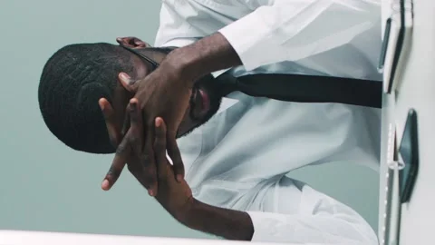Vertical shot of handsome tired African American businessman putting glasses off Stock Footage 131784580
