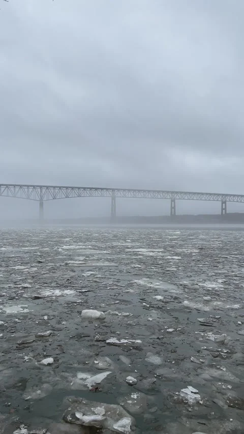 Vertical Shot of Ice Moving on River in Front of Bridge Stock Footage 265112151