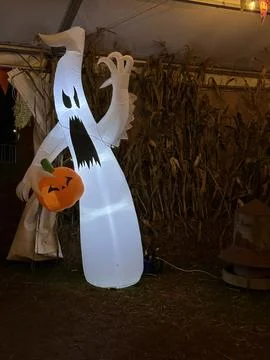 Vertical shot of an inflatable ghost with jack o lantern pumpkin halloween de Stock Photos