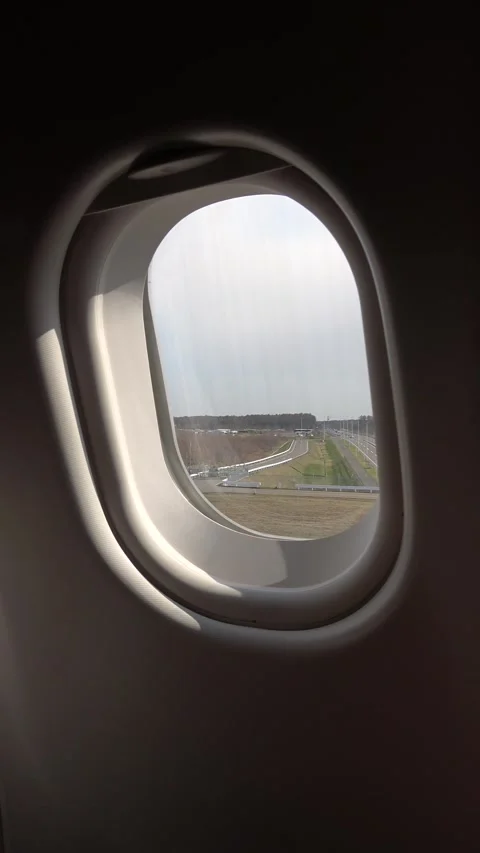 Vertical shot: Inside an airplane, view of taxiing on the taxiway. Video stock 307710820
