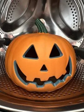 Vertical shot of jack-o-lantern halloween pumpkin in washing machine Stock Photos
