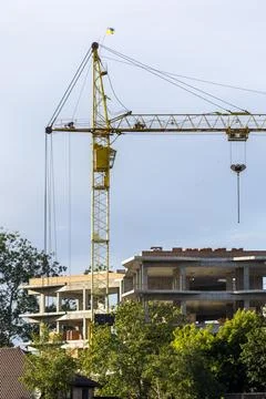 A vertical shot of a large yellow construction crane operating at a developme Foto stock