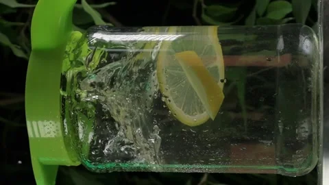 Vertical shot, lemon is thrown into a carafe of water, slow motion Stock Footage 266560911