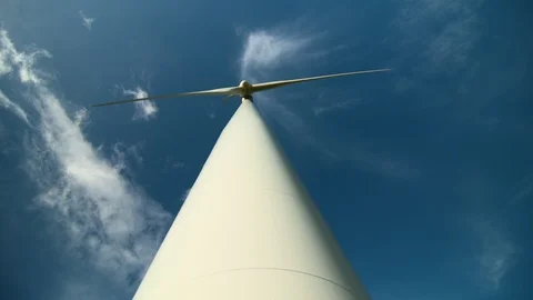 Vertical shot looking up at wind turbine in operation against blue sky. Stock Footage 87878908