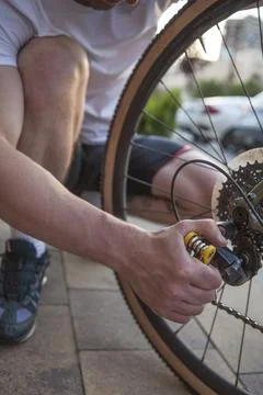Vertical shot of a man using multitool to repair his bicycle Stock Photos