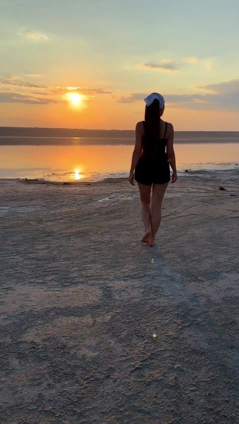 Vertical Shot of Man Walking on Estuary Beach at Sunset Stock Footage 342132163