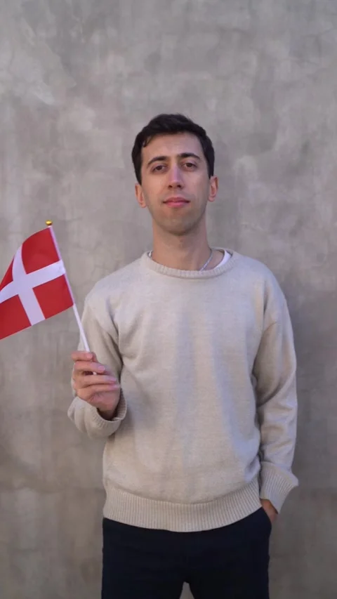 Vertical shot of a man waving Danish flag. Concept of patriotism. Slow motion. Stock Footage 340315334