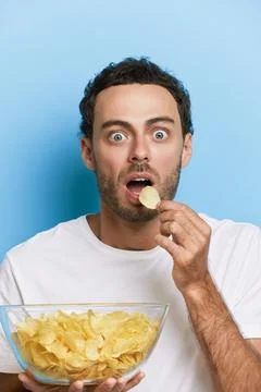 Vertical shot of a man with wide opened eyes and mouth watching a tv amazed with Stock-Fotos