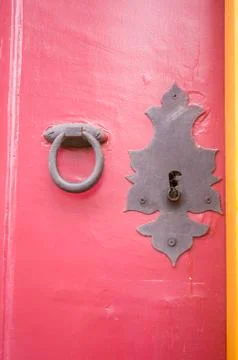 Vertical shot of medieval old knobs and locks on a red door Fotos de archivo