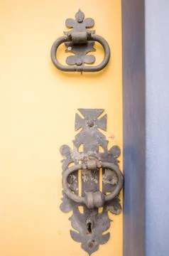 Vertical shot of medieval old knobs and locks on a yellow door Fotos de archivo
