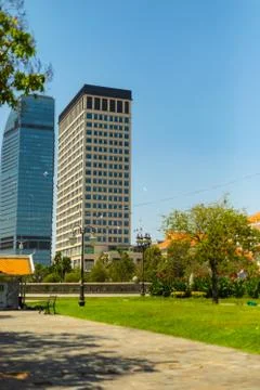 A vertical shot of a modern office building with a park in the foreground in  Fotos de archivo