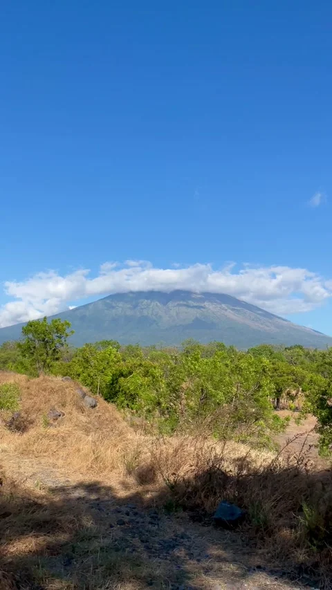 Vertical Shot of Mount Agung with Ring Cloud Under Blue Sky Vidéo 341552183