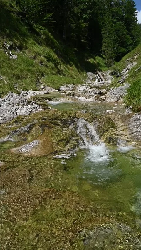 Vertical shot of a mountain stream with sunlight effects, slow motion Stock-Footage 260881469