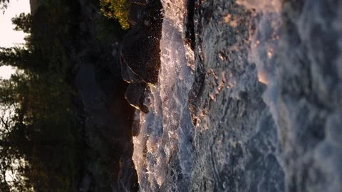 Vertical shot. A mountain stream at sunset. Splashing water. Stock Footage 249011625