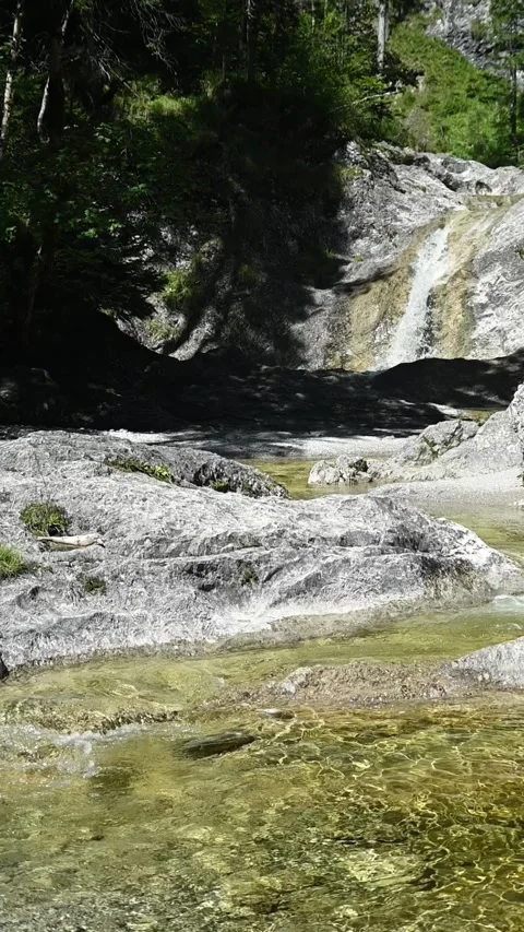 Vertical shot of a mountain stream with a waterfall in summer 스톡 동영상 260911801