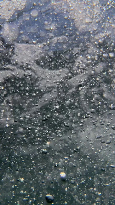 Vertical shot of numerous tiny air bubbles and small particles drifting Stock Footage 335759144
