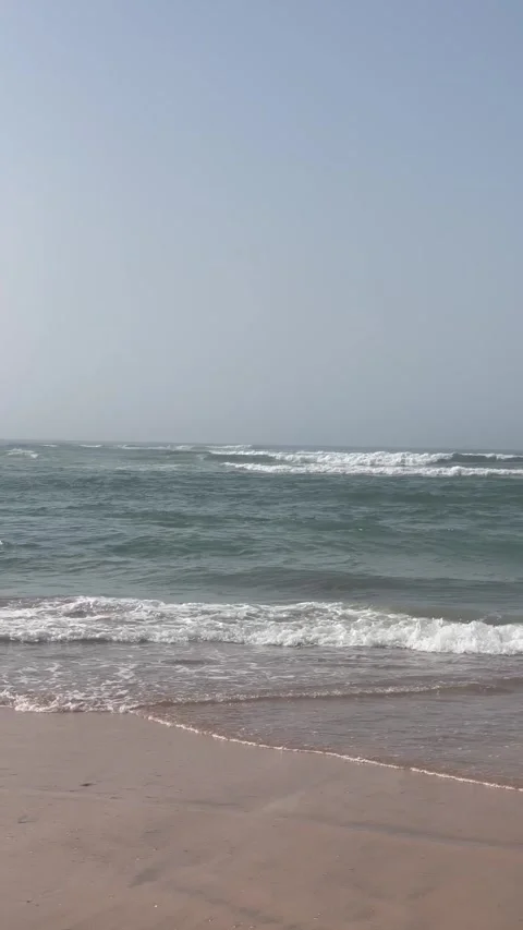 Vertical Shot of Ocean Waves Crashing on Sandy Beach Shoreline Stock Footage 340774871